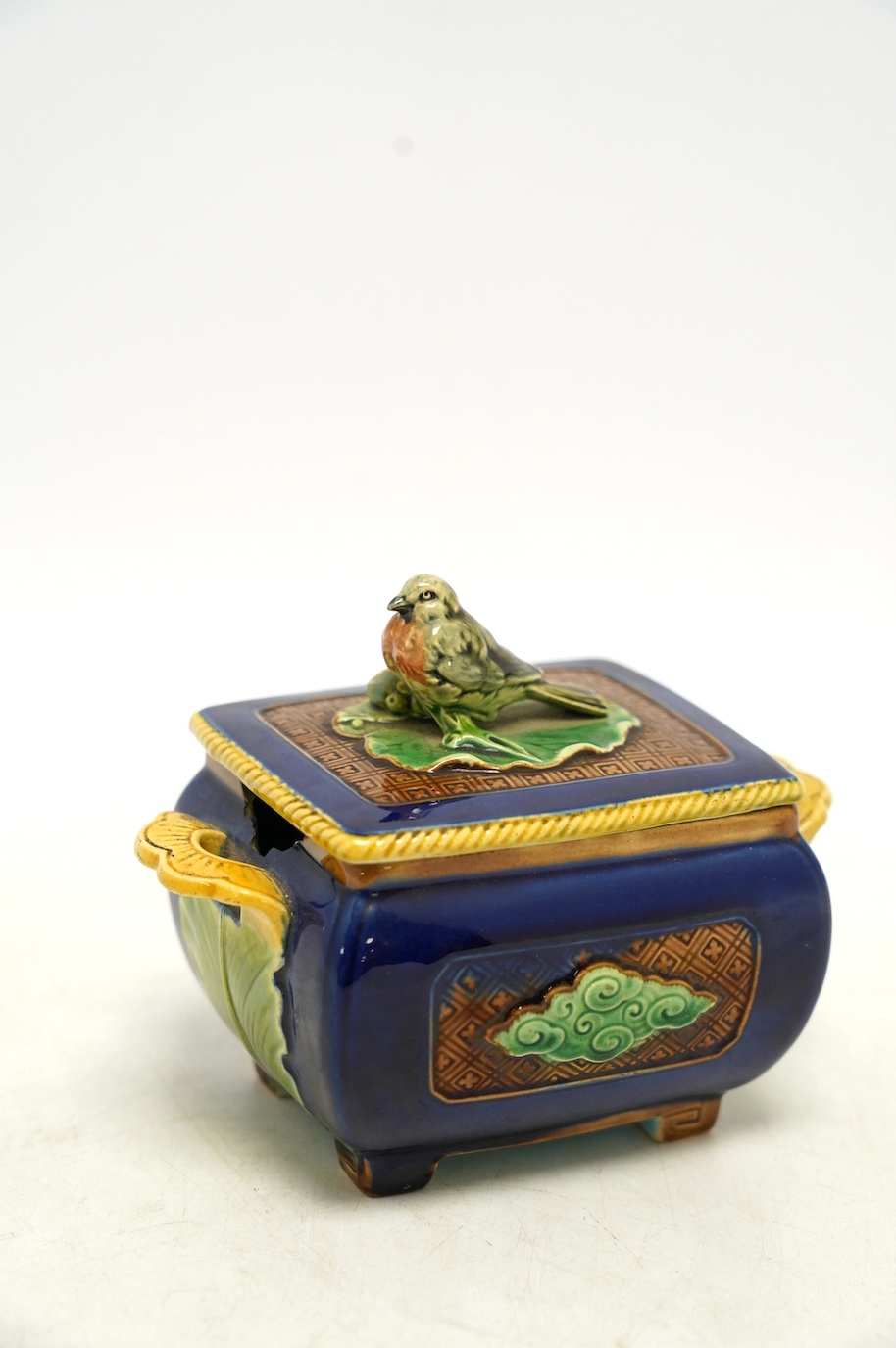 A small Minton majolica box and cover, possibly after a design by Christopher Dresser, 13cm wide. Condition - poor